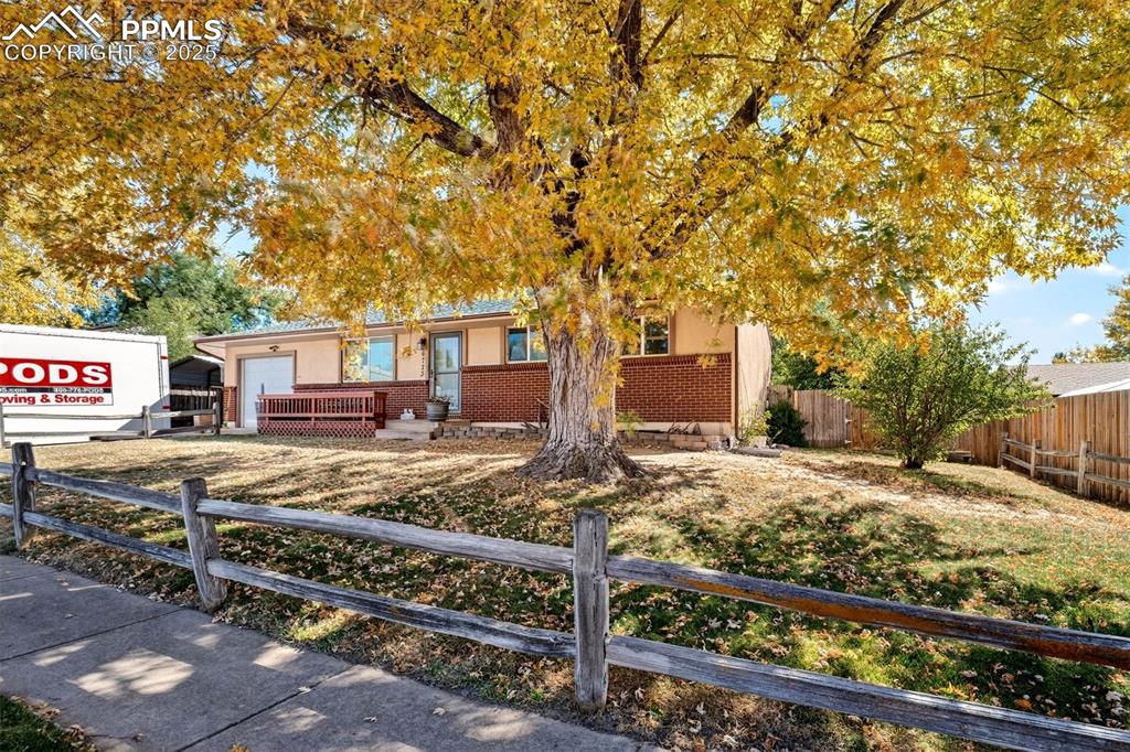 Image 2 of 36: Stucco and brick exterior with large front and back yards with mature trees
