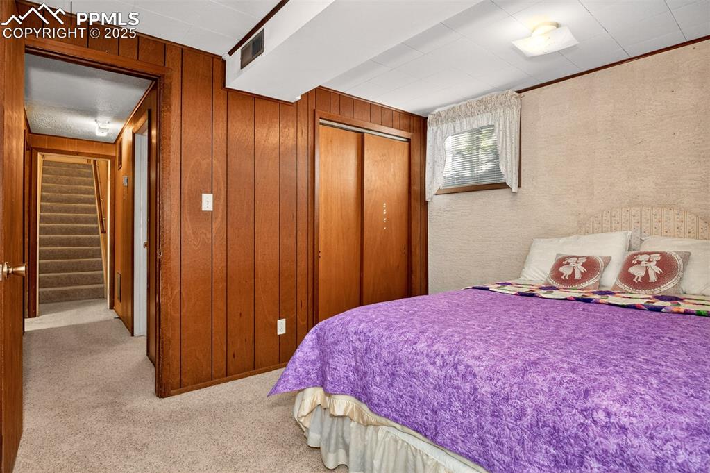 Image 24 of 36: Wood paneled accent wall adds warmth to the space