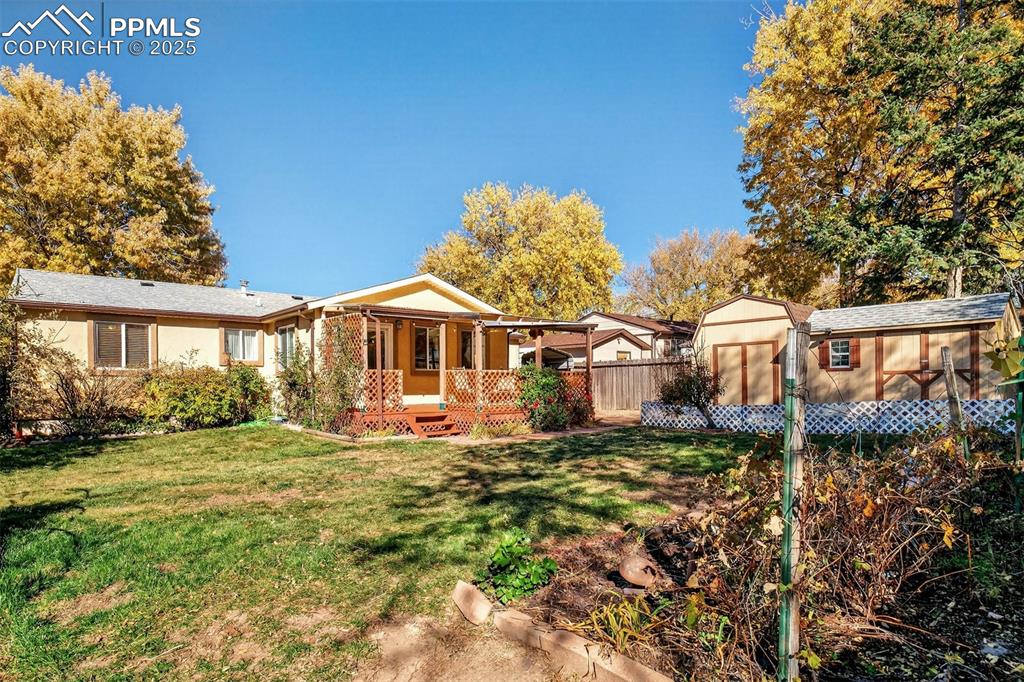 Image 28 of 36: The back yard is landscaped and includes more storage space with its 3 wood