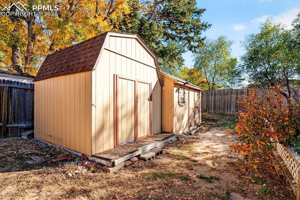 Image 33 of 36: Wood sheds give you options to store other items like landscaping tools.