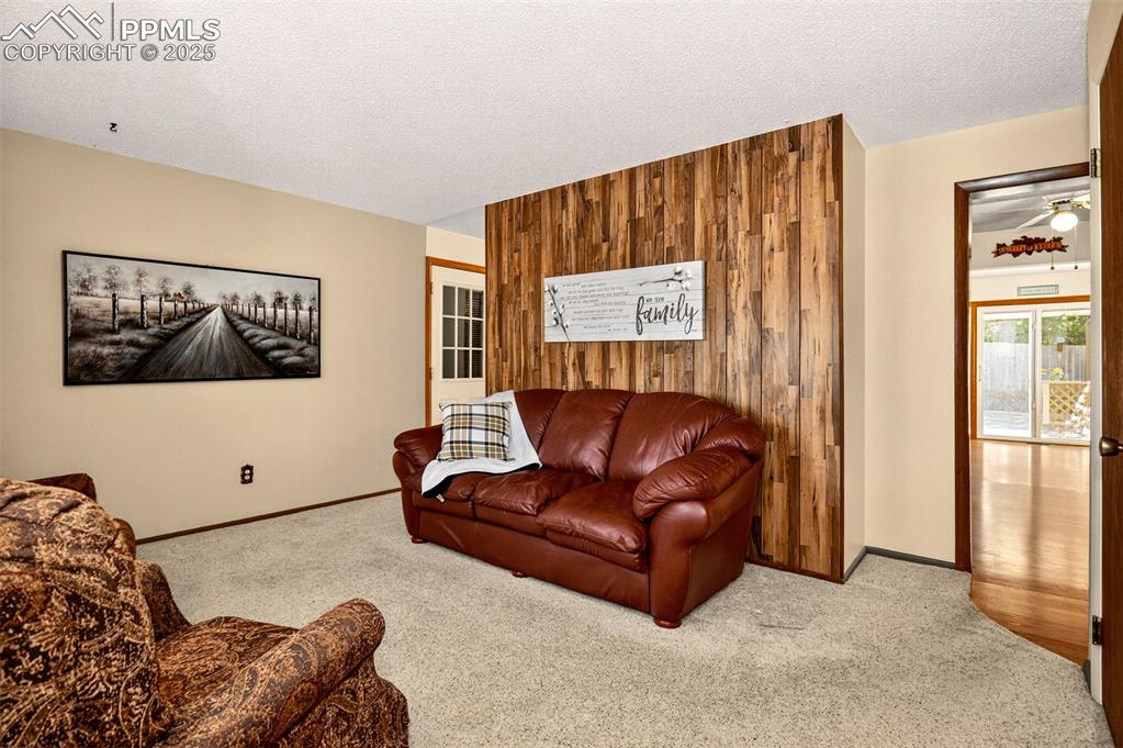 Image 4 of 36: Wood panel accent walls and dual access to the kitchen and dining areas
