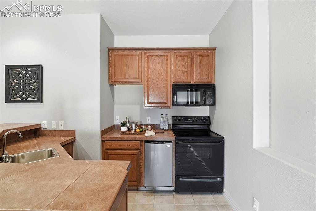 Image 26 of 50: Basement Kitchen with Dishwasher & Full Range/Oven