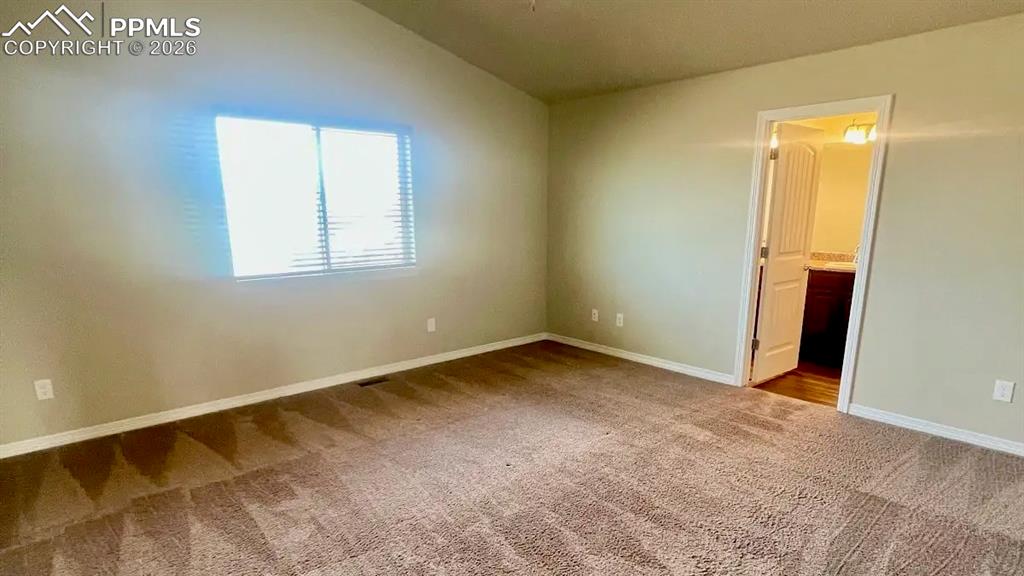 Image 5 of 15: Spacious primary bedroom with vaulted ceilings