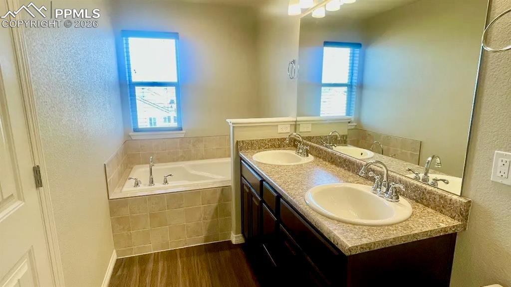 Image 6 of 15: Spacious primary bathroom with dual vanities and soaking tub