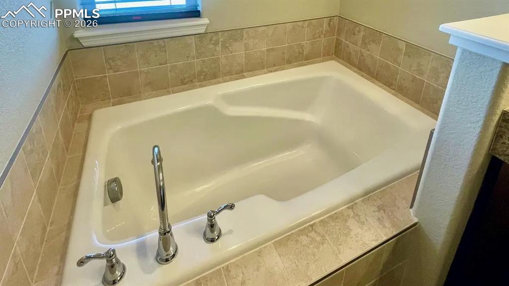 Image 8 of 15: Deep soaking tub in the primary bath