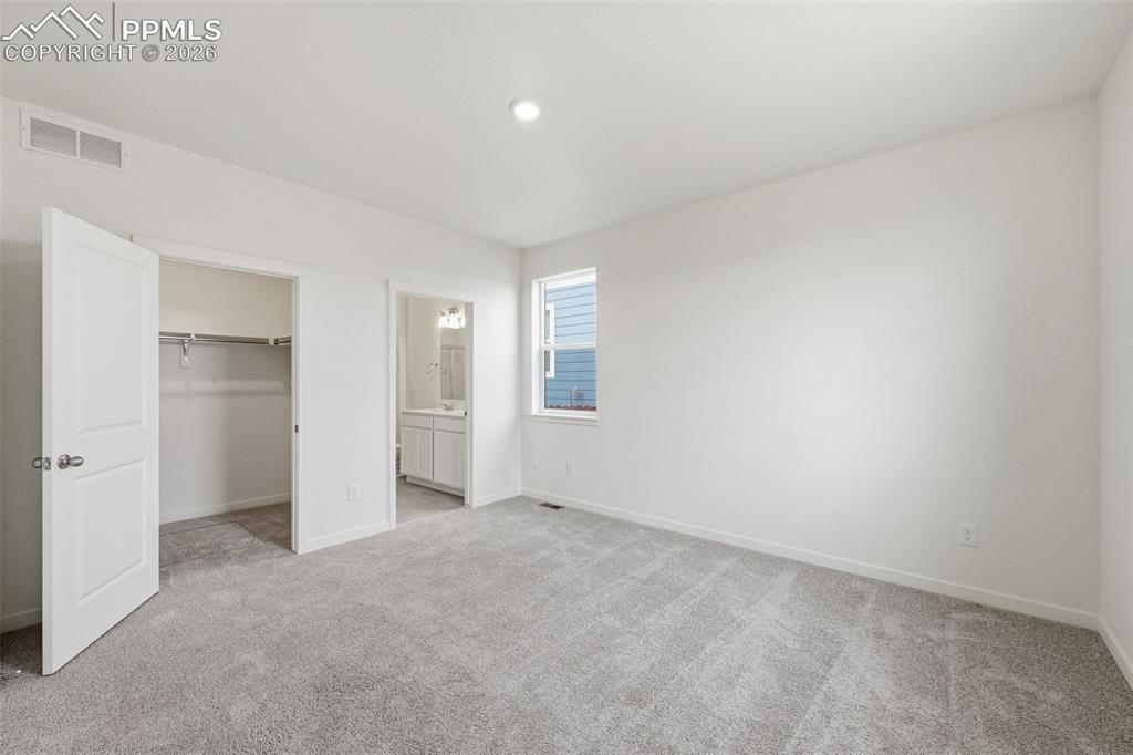 Image 10 of 23: Spacious room with light gray carpeting, neutral wall finishes, and a singl