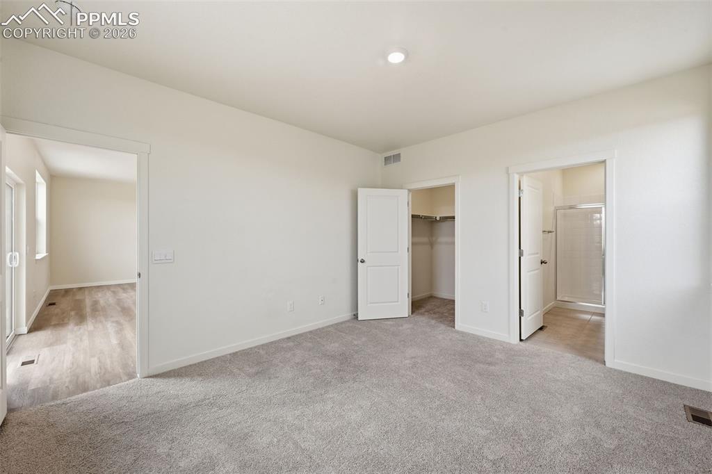 Image 11 of 23: Rear exterior featuring a sliding glass door, a privacy fence, and a gravel