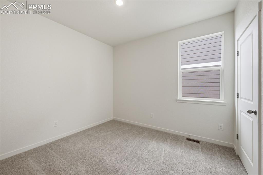 Image 14 of 23: Carpeted sleeping area featuring a window with horizontal blinds and a priv