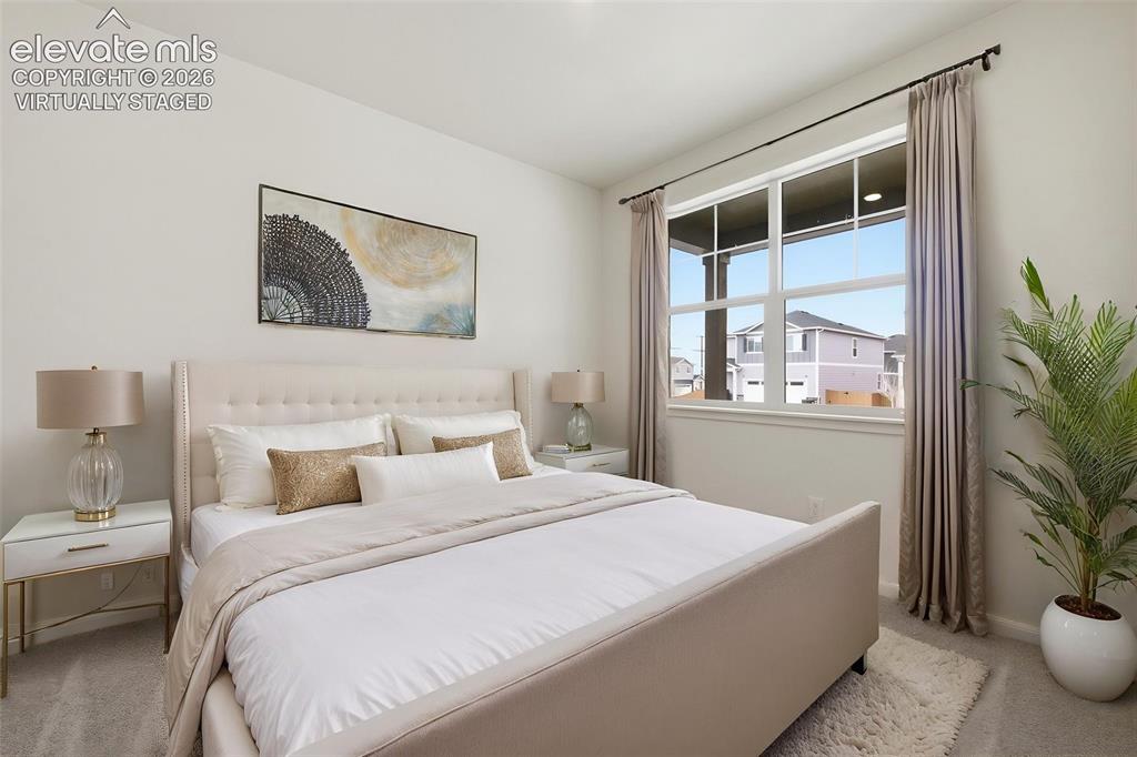 Image 16 of 23: Virtually Staged Photo. Carpeted room featuring a large window with white f