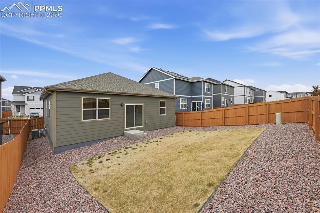 Image 22 of 23: Expansive backyard featuring a partial lawn area, gravel landscaping, and a