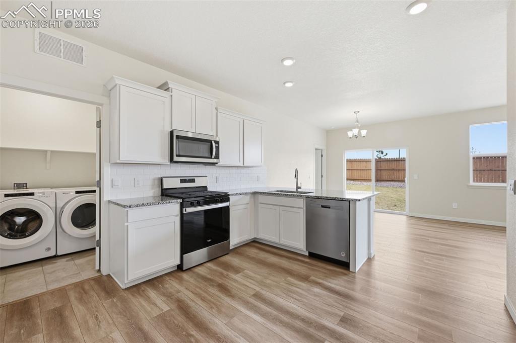 Image 3 of 23: Kitchen with white shaker cabinetry, stainless steel appliances, granite co