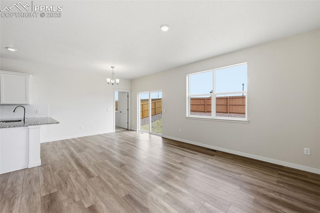 Image 8 of 23: Open concept living area featuring wood-finish flooring, recessed lighting,