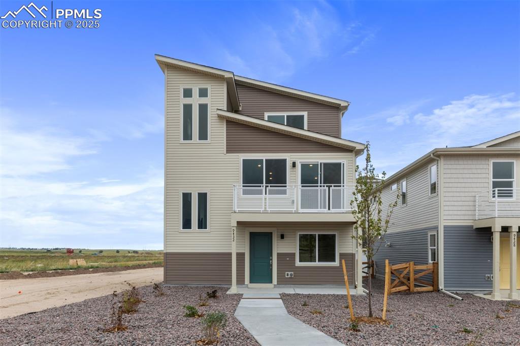 Caption: Modern home featuring a balcony and a porch