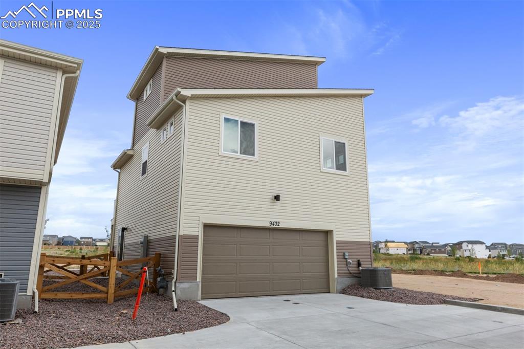 Image 3 of 6: Back of house featuring concrete driveway and an attached garage