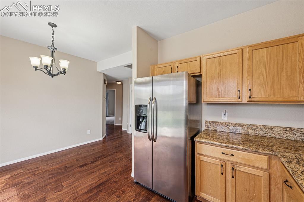Image 13 of 39: Kitchen with stainless steel fridge with ice dispenser, a chandelier, decor