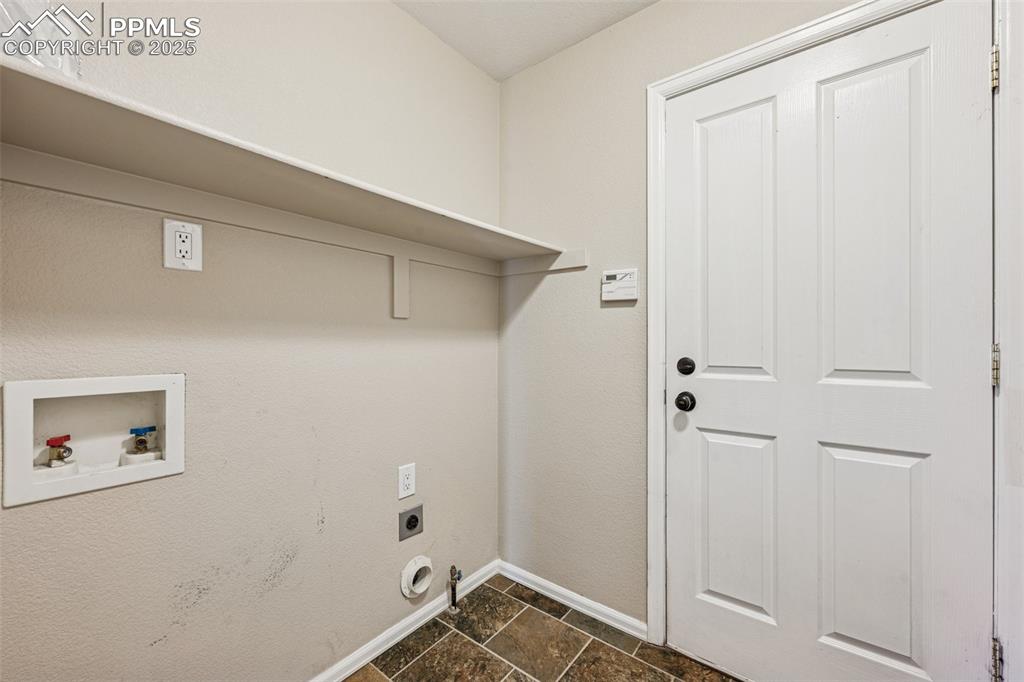 Image 19 of 39: Laundry room with washer and dryer hookup.  Located off garage entrance to 