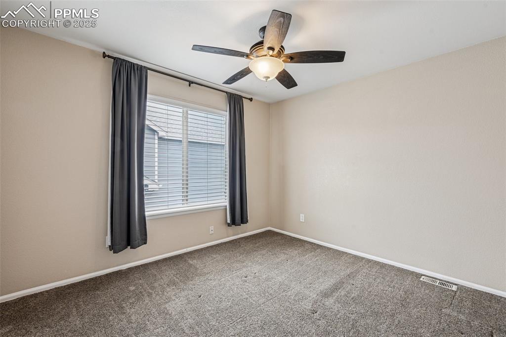 Image 21 of 39: 3rd bedroom with ceiling fan & separate bath