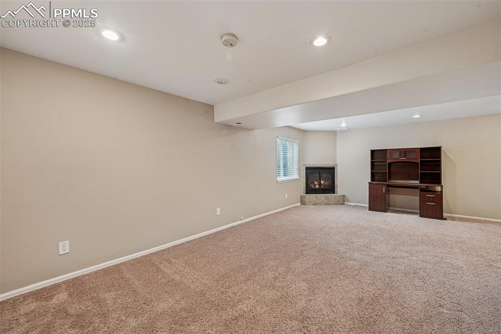 Image 24 of 39: Basement Family room with hi ceilings, fireplace, and recessed lighting