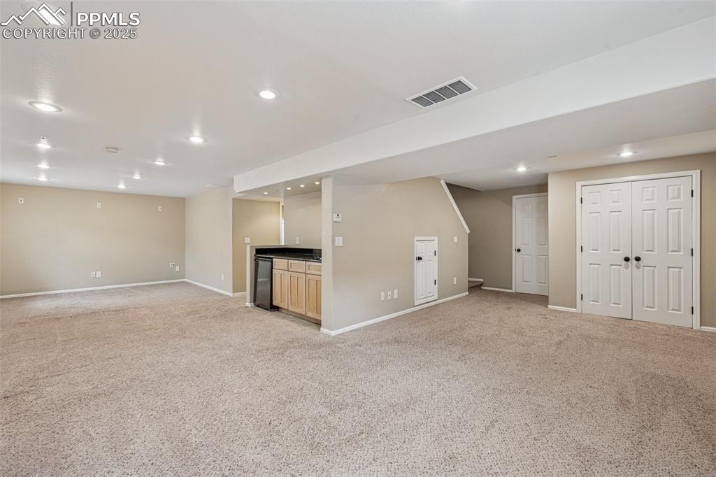 Image 25 of 39: Finished basement featuring wet bar with sink, and recessed lighting