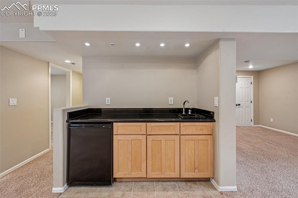 Image 26 of 39: Wet bar with sink and refrigerator for entertaining