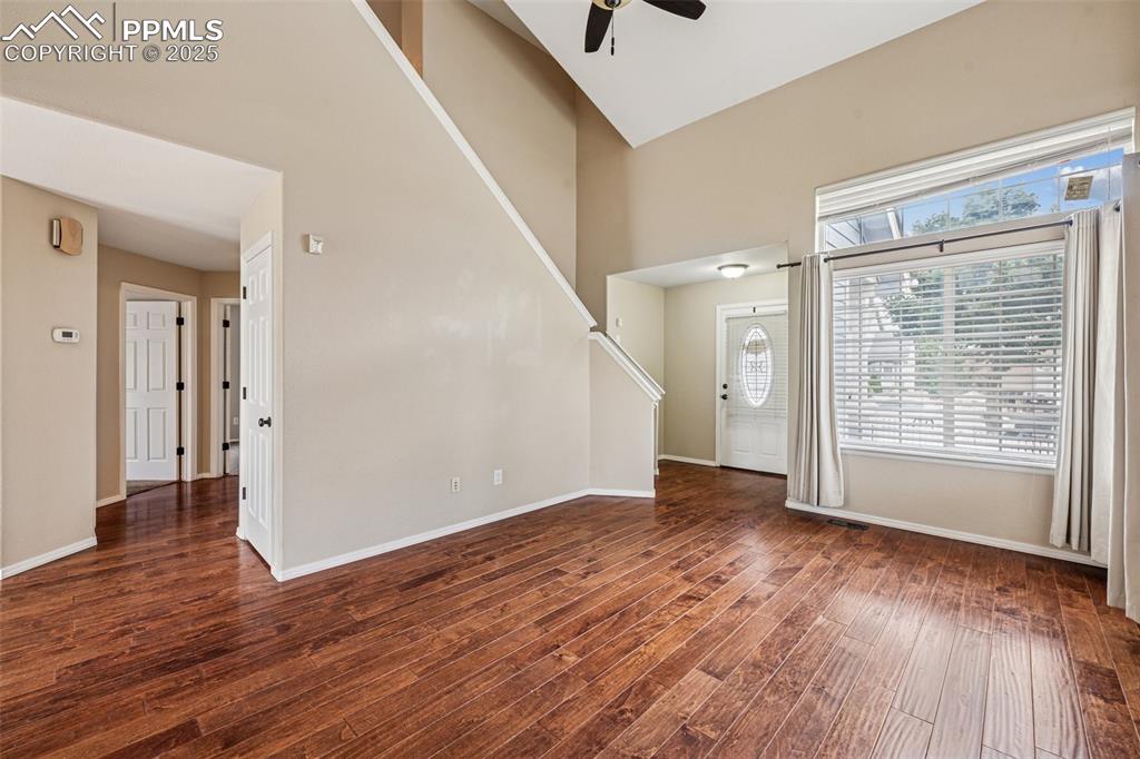 Image 6 of 39: Living room with high ceiling, wood finished floors, plenty of natural ligh