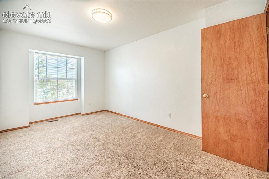 Image 20 of 38: Carpeted interior room featuring a large window, a flush-mount ceiling ligh