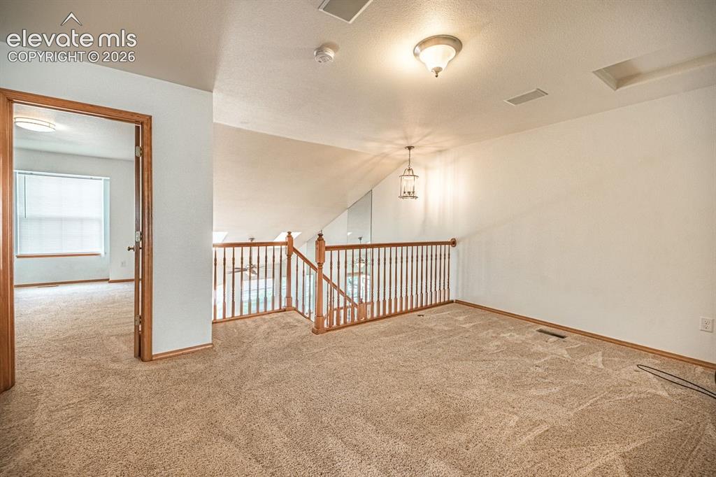 Image 26 of 38: Carpeted upper-level landing featuring a