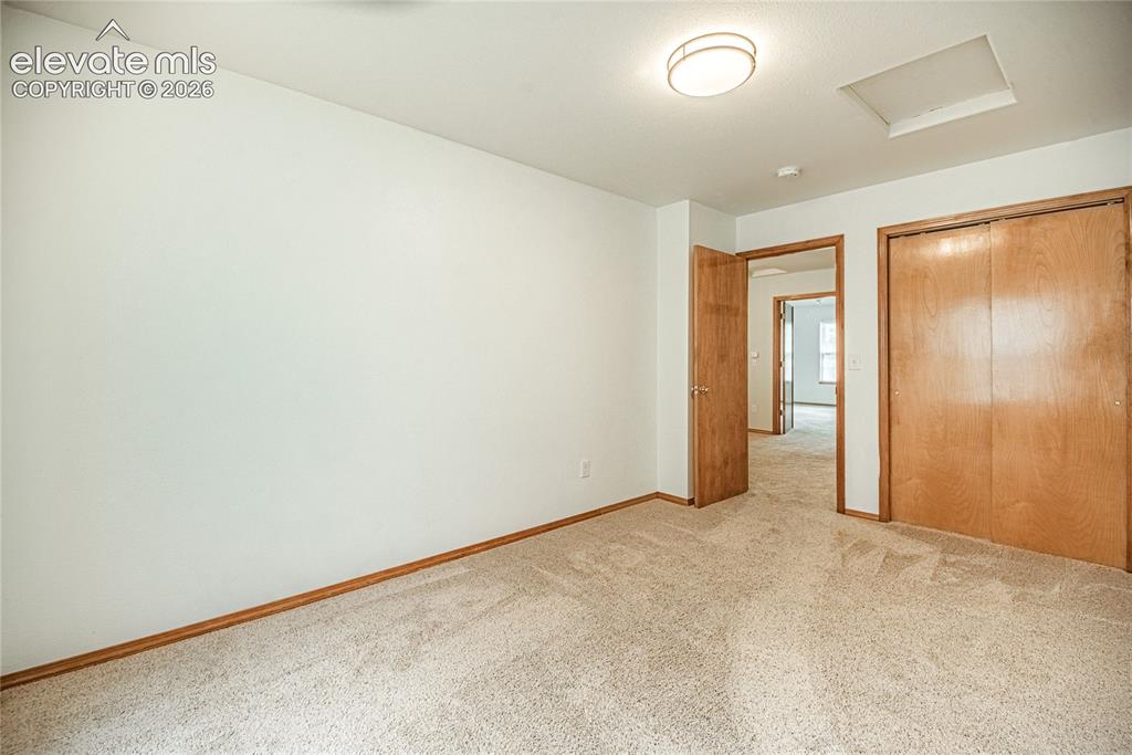 Image 29 of 38: Carpeted room with light wood-finish trim, a flush-mount ceiling light, and