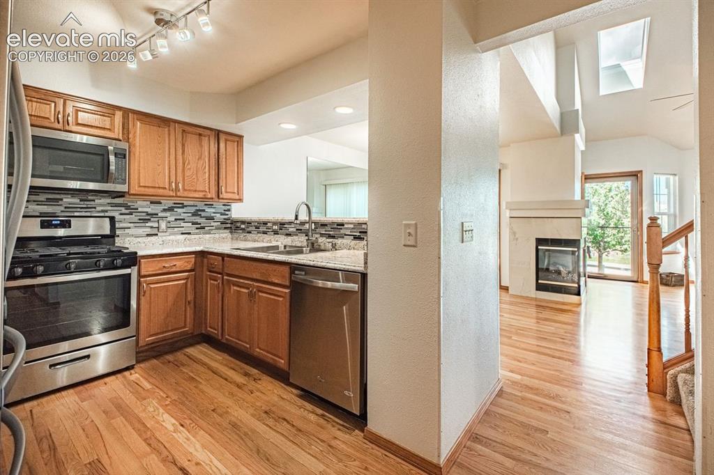 Image 3 of 38: Kitchen featuring wood cabinetry, gas stove, stainless steel appliances, a