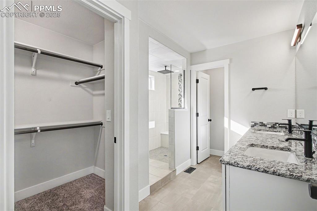 Image 16 of 20: Primary bedroom walk in closet, double granite vanities with undermount sin