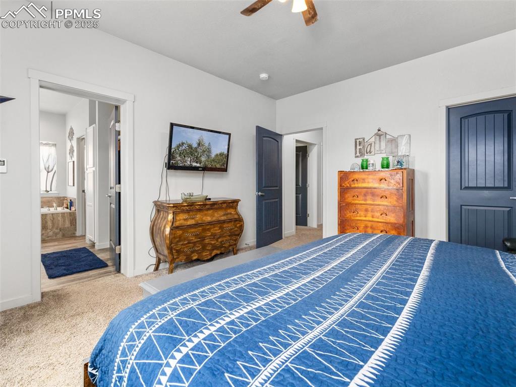 Image 15 of 25: Bedroom featuring carpet, ceiling fan, and ensuite bath