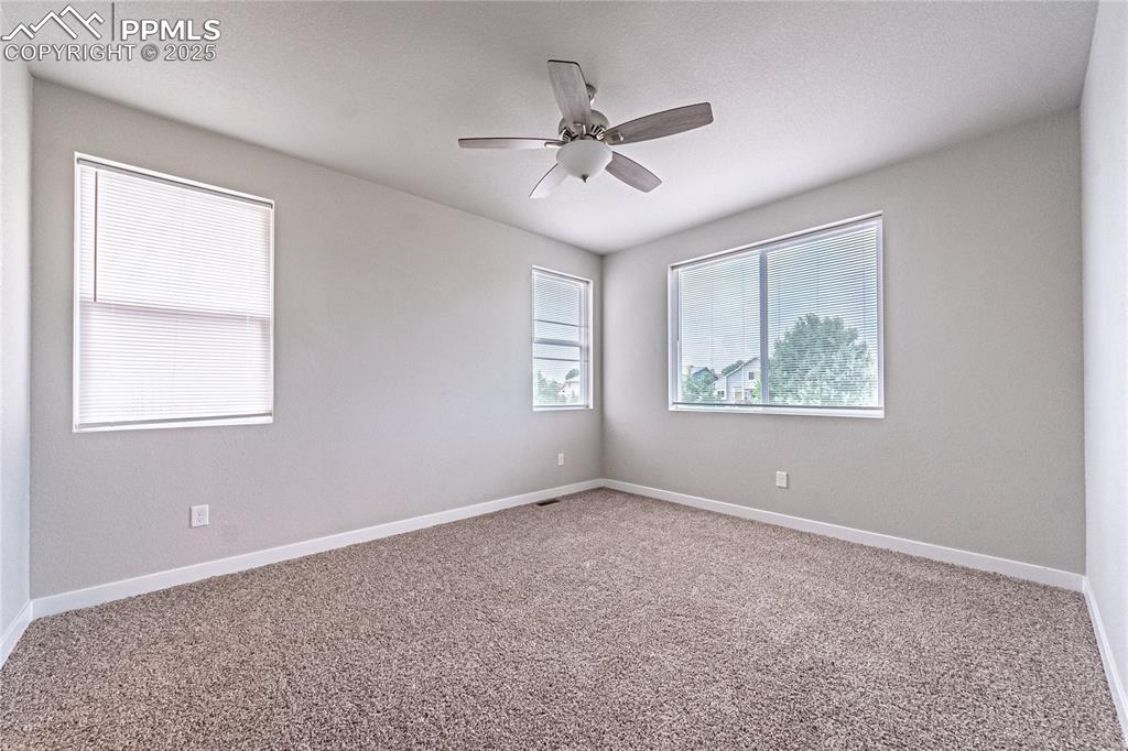 Image 11 of 39: Carpeted spare room featuring baseboards and a ceiling fan
