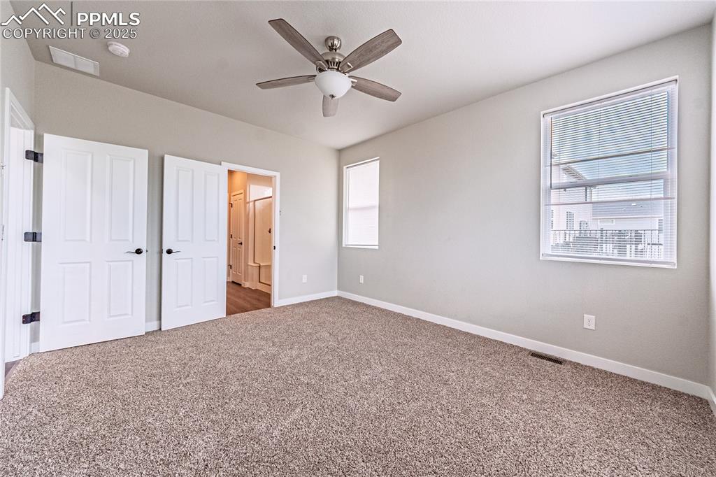 Image 15 of 39: Unfurnished bedroom with carpet and a ceiling fan