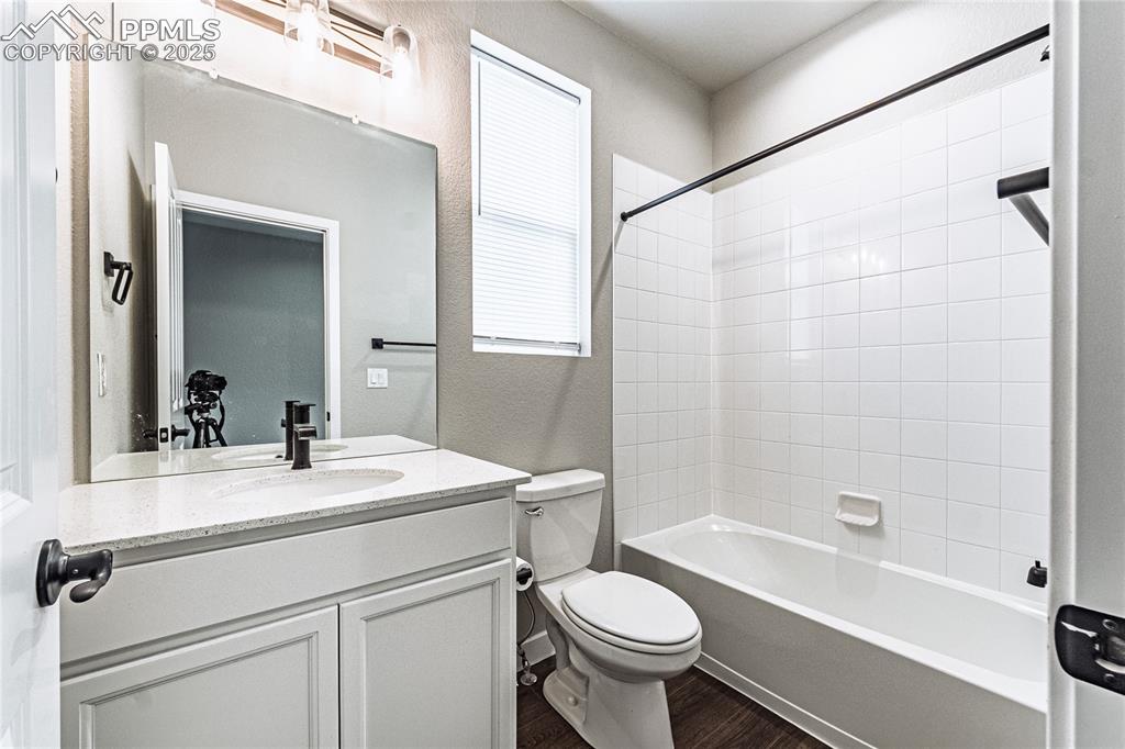 Image 19 of 39: Full bath with vanity, washtub / shower combination, a textured wall, and w