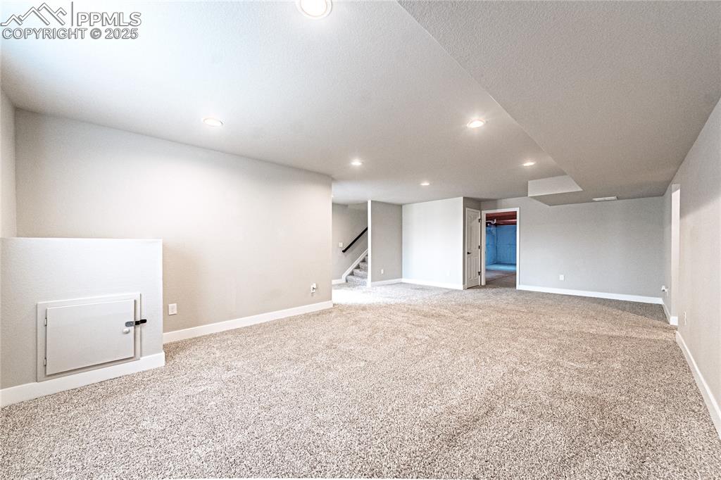 Image 24 of 39: Finished basement featuring carpet, recessed lighting, and stairway