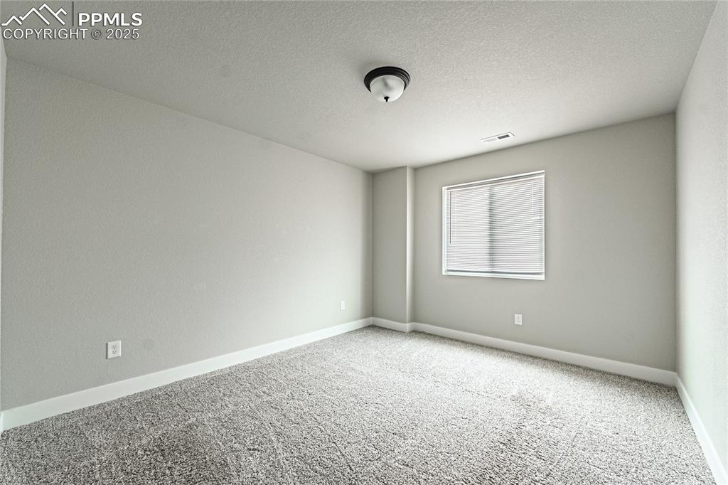 Image 27 of 39: Carpeted empty room with baseboards and a textured ceiling