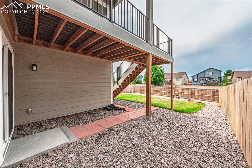 Image 32 of 39: Fenced backyard featuring stairway and a patio