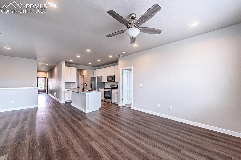 Image 4 of 39: Kitchen with open floor plan, recessed lighting, dark wood-style flooring,