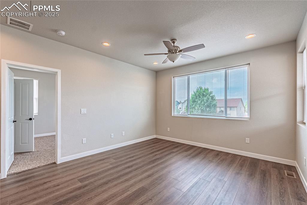 Image 8 of 39: Empty room featuring dark wood-style flooring, a textured ceiling, recessed