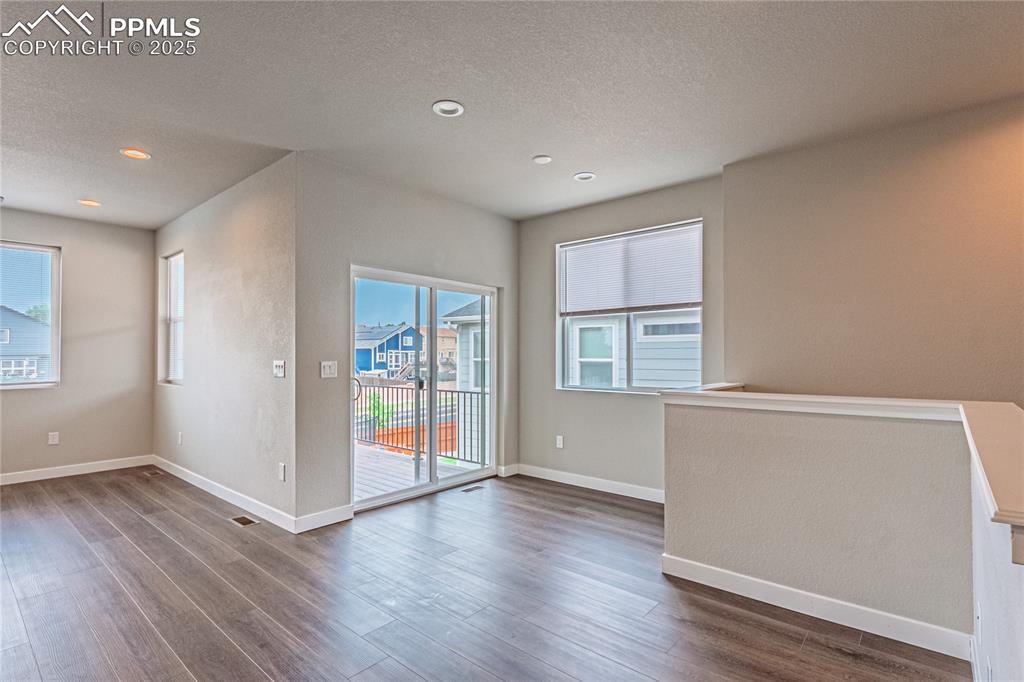 Image 9 of 39: Unfurnished dining area featuring dark wood-style flooring, a textured ceil
