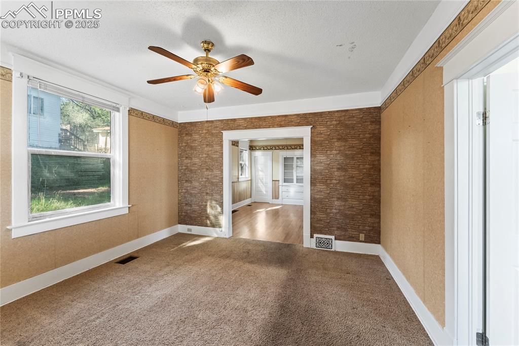 Image 3 of 27: Spare room with carpet, a ceiling fan, and a textured ceiling