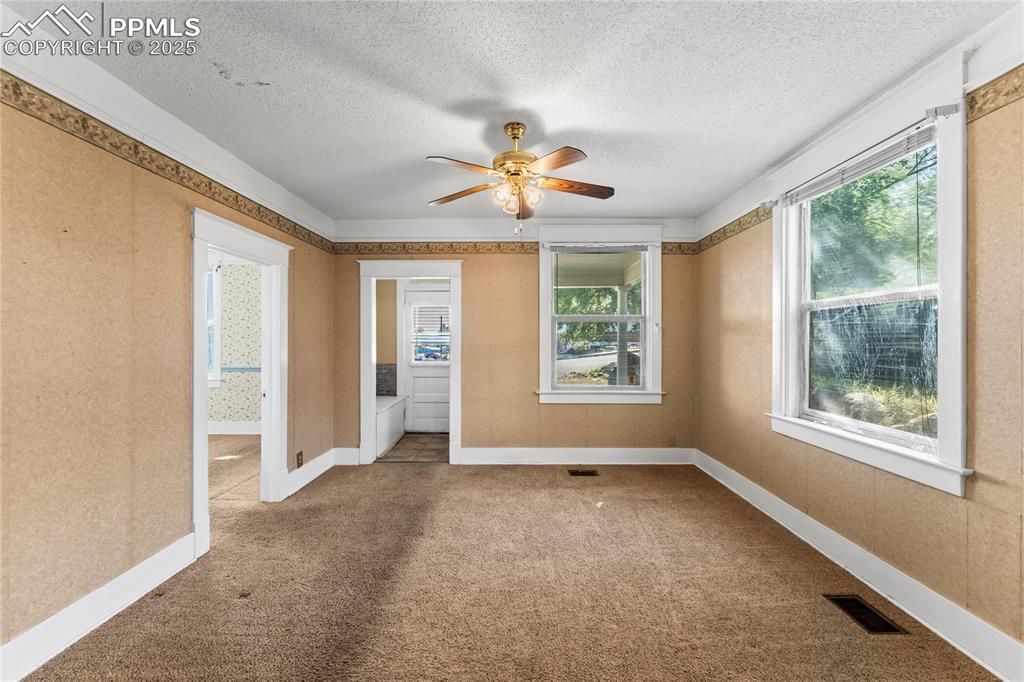 Image 4 of 27: Unfurnished room with carpet floors, a textured ceiling, and a ceiling fan