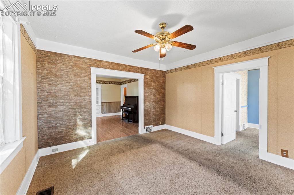 Image 5 of 27: Unfurnished room with carpet floors and a ceiling fan