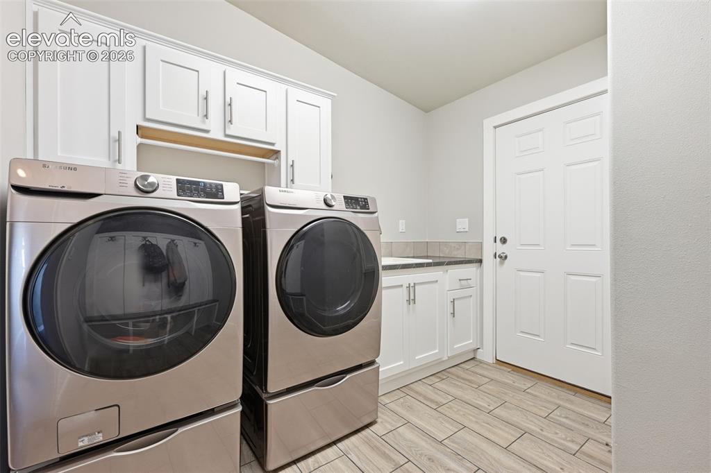 Image 24 of 27: Mud room with cubbies, bench seating, and coat hooks designed for country l