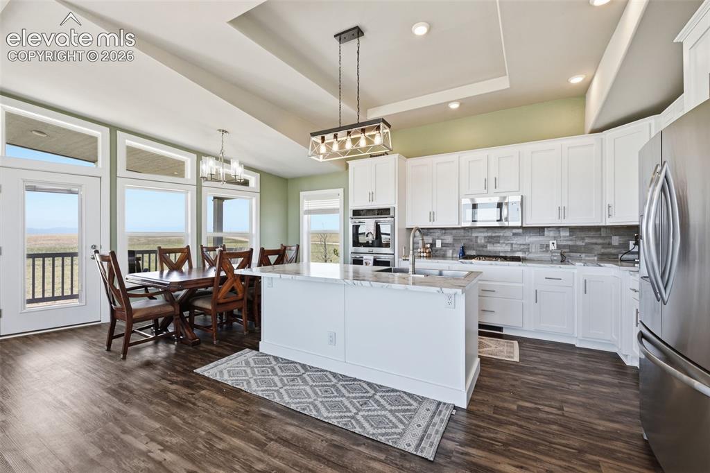 Image 6 of 27: Vaulted great room filled with natural light and expansive windows