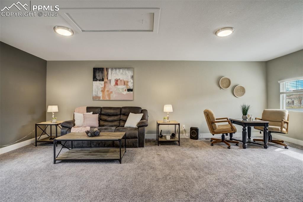 Image 12 of 29: Living room with carpet and attic access