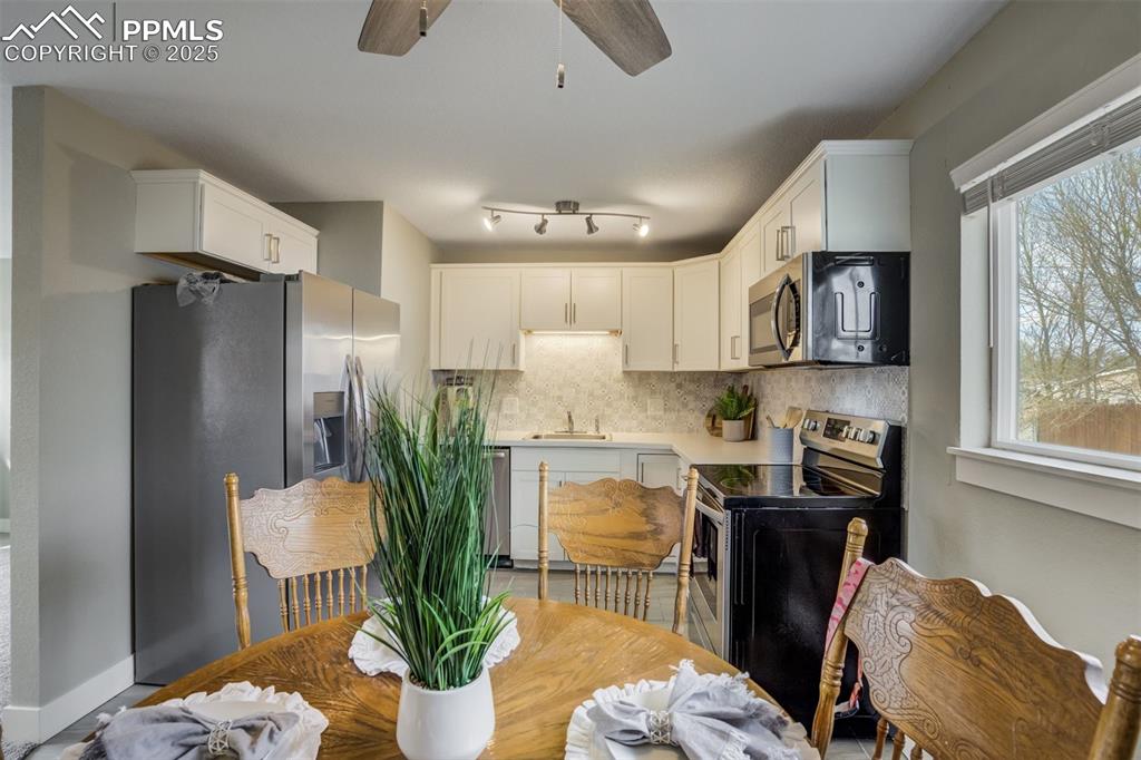 Image 9 of 29: Kitchen with light countertops, stainless steel appliances, decorative back
