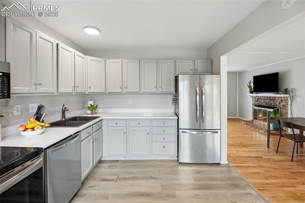 Image 12 of 39: Kitchen featuring appliances with stainless steel finishes, light counterto