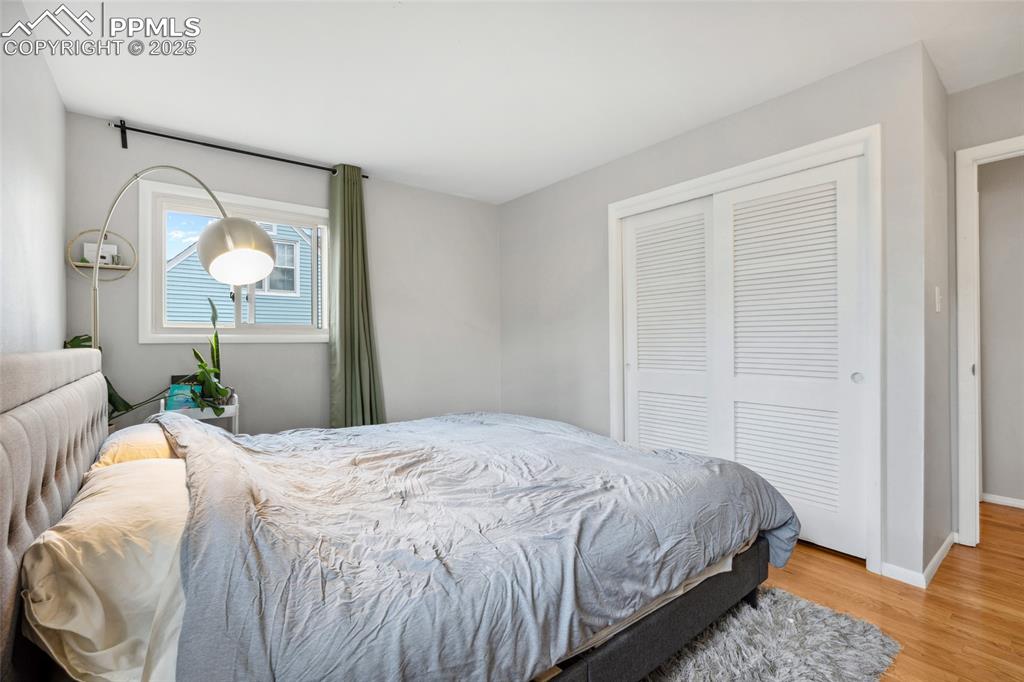 Image 13 of 39: Bedroom with wood finished floors, baseboards, and a closet
