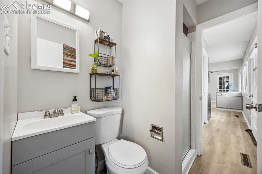 Image 16 of 39: Bathroom featuring wood finished floors, visible vents, toilet, and vanity
